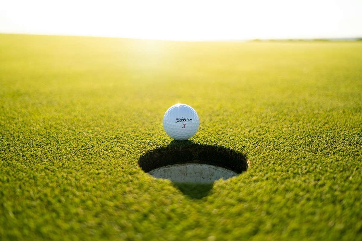A golf ball beside the hole on a putting green